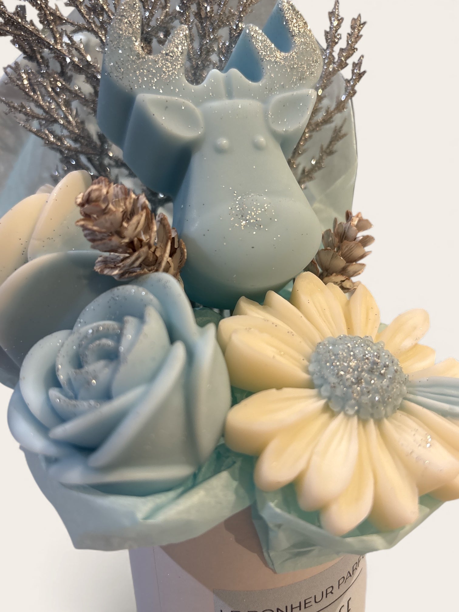 Détails du bouquet Bleu Glacial, renne bleu pailleté et fleurs en cire parfumée